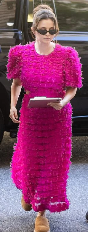 Исполнительница надела розовое платье с воланами, которое контрастировало с обувью на съёмочной площадке