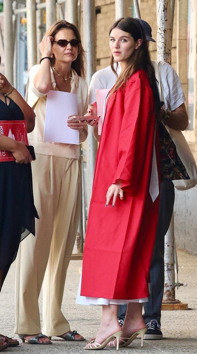 Для церемонии в United Palace Theatre в Вашингтон-Хайтс, девушка надела длинное белое платье под ярко-красную мантию, открытые сандалии и распустила длинные волосы.