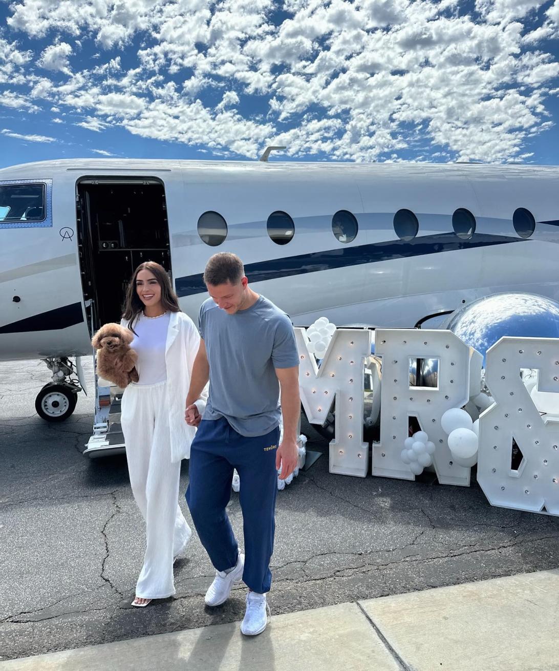 Оливия Калпо и Кристиан Маккафри на фоне частного самолета.