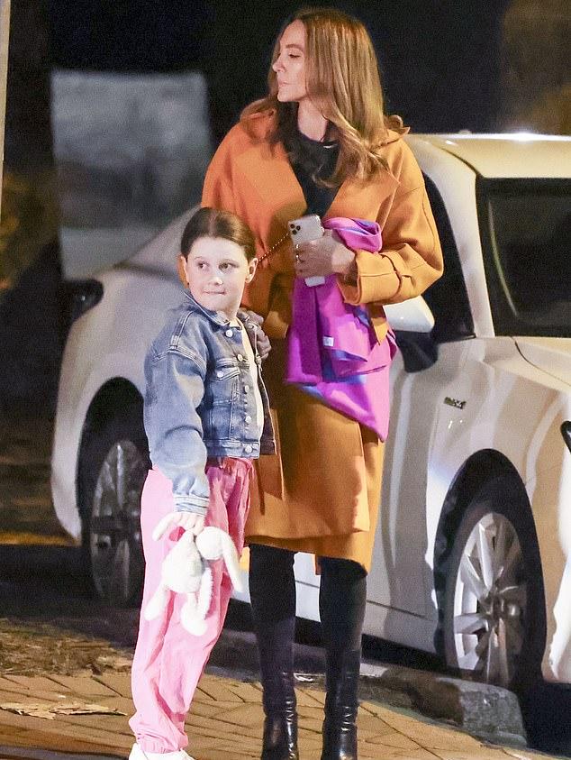 Держа в одной руке телефон, а в другой розовую курточку, Кайли выглядела как стильная мама