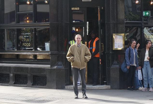 Ее видели стоящей на улице возле лондонского паба Rising Sun на Tottenham Court Road в серых брюках и черных кроссовках