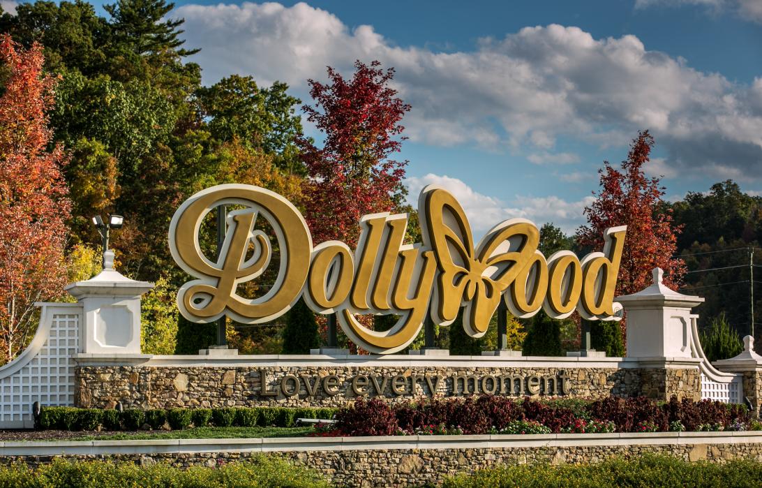 Вход в Долливуд.  (Vhod v Dollivud.)</p>
<p>Improved/shorter options (depending on desired nuance):</p>
<p>* Долливуд. (Dollivud.) - Simply "Dollywood."
* У входа в Долливуд. (U vkhoda v Dollivud.) - "At the entrance to Dollywood."  More evocative.